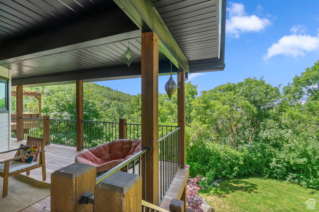Deck with a forest view and a lawn