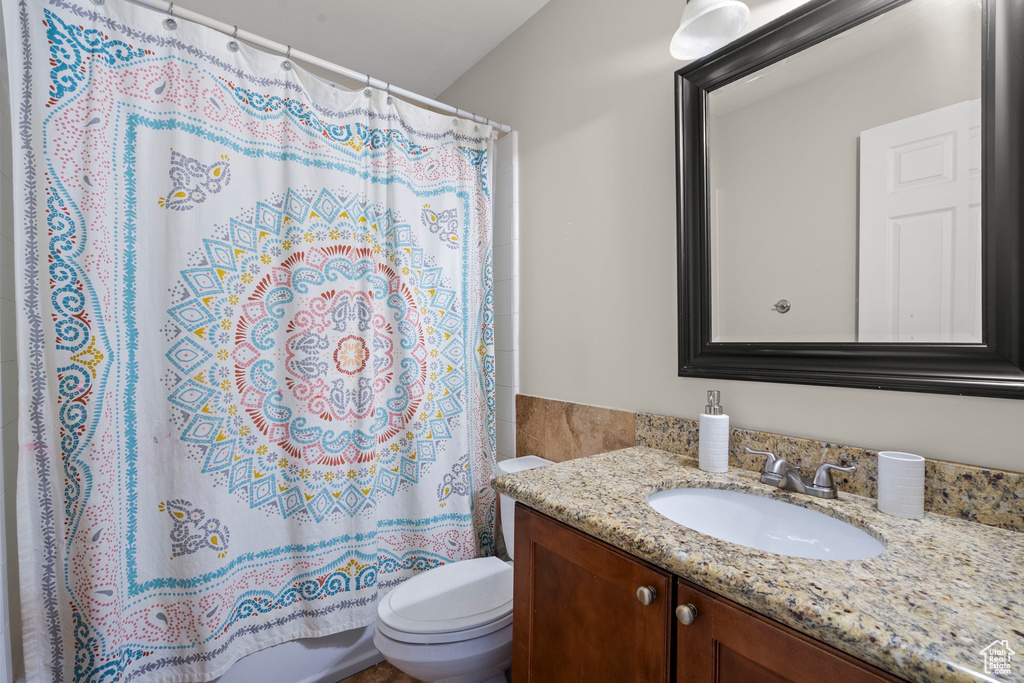 Bathroom with vanity, toilet, and a shower with shower curtain