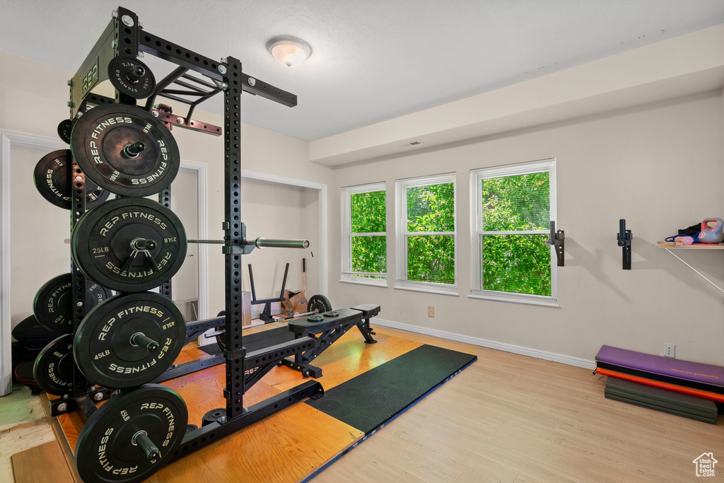 Exercise room with wood finished floors and baseboards
