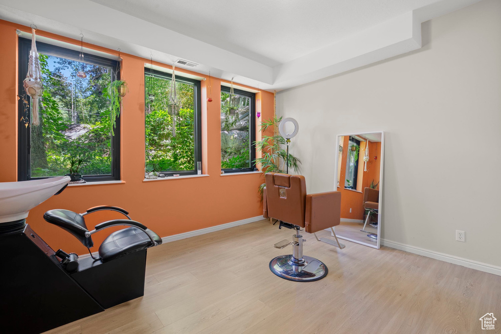 Living area with wood finished floors, healthy amount of natural light, baseboards, and a tray ceiling