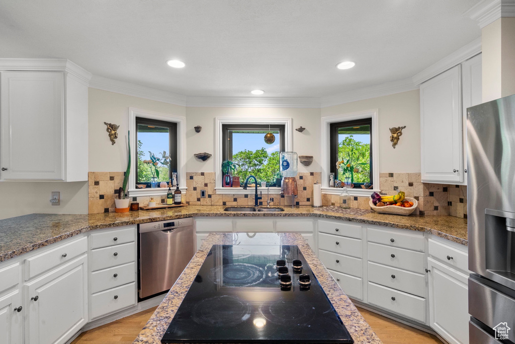 Kitchen featuring stainless steel appliances, a sink, white cabinetry, recessed lighting, and crown molding
