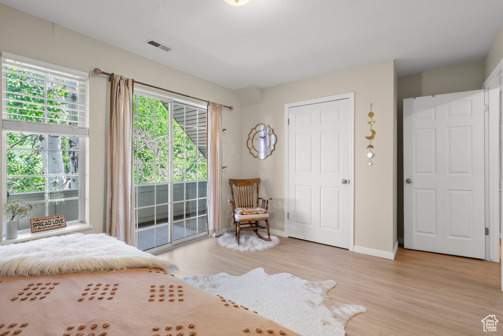 Bedroom with access to outside, light wood-style flooring, and baseboards