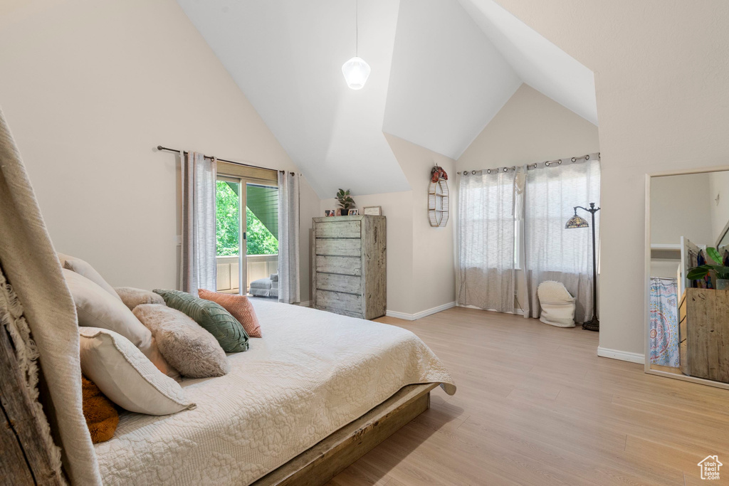 Bedroom featuring light wood-style flooring, lofted ceiling, and baseboards