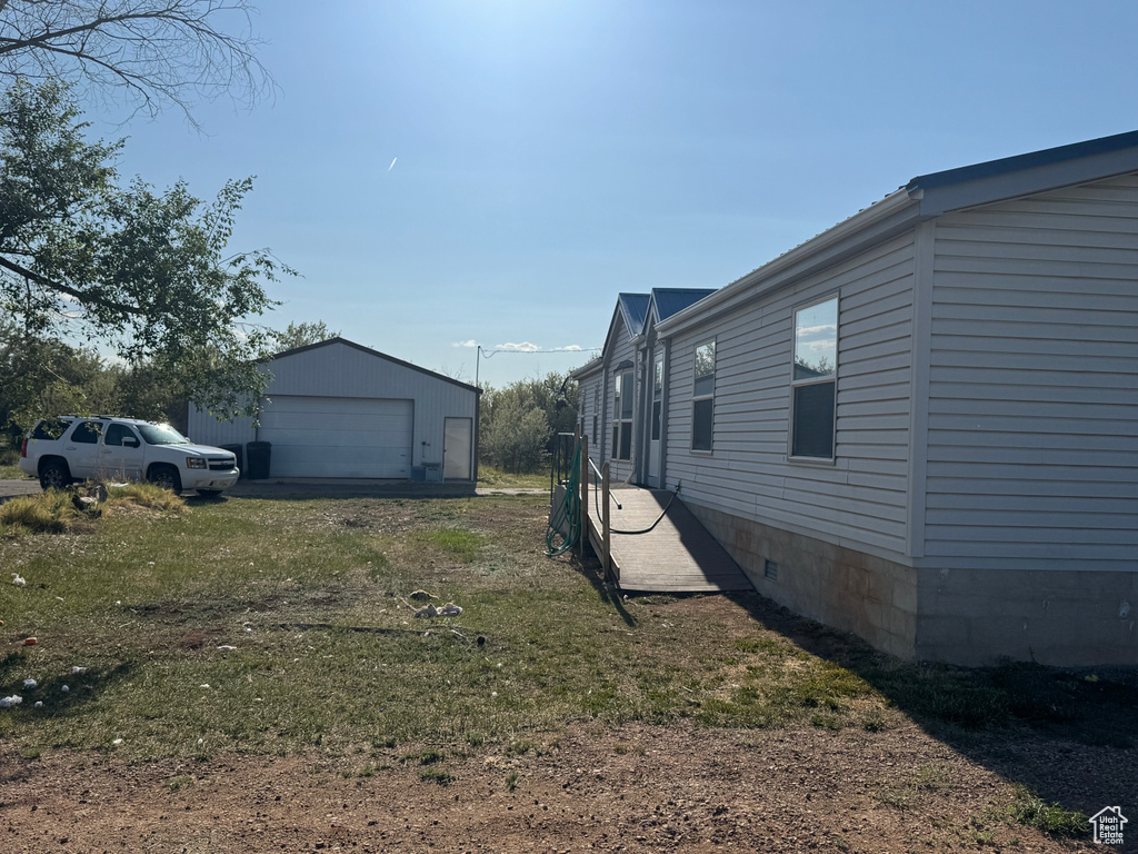 View of yard with a detached garage and an outbuilding