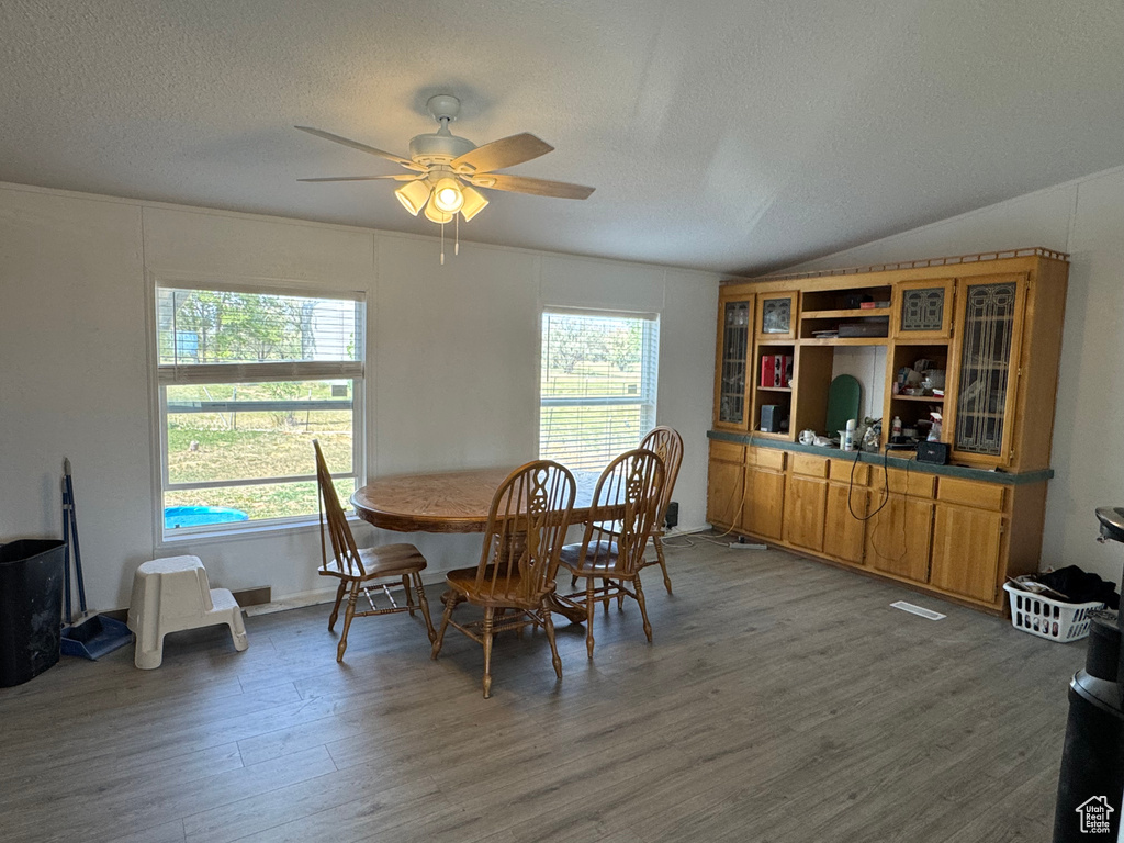 Dining room with a textured ceiling, wood finished floors, and ceiling fan