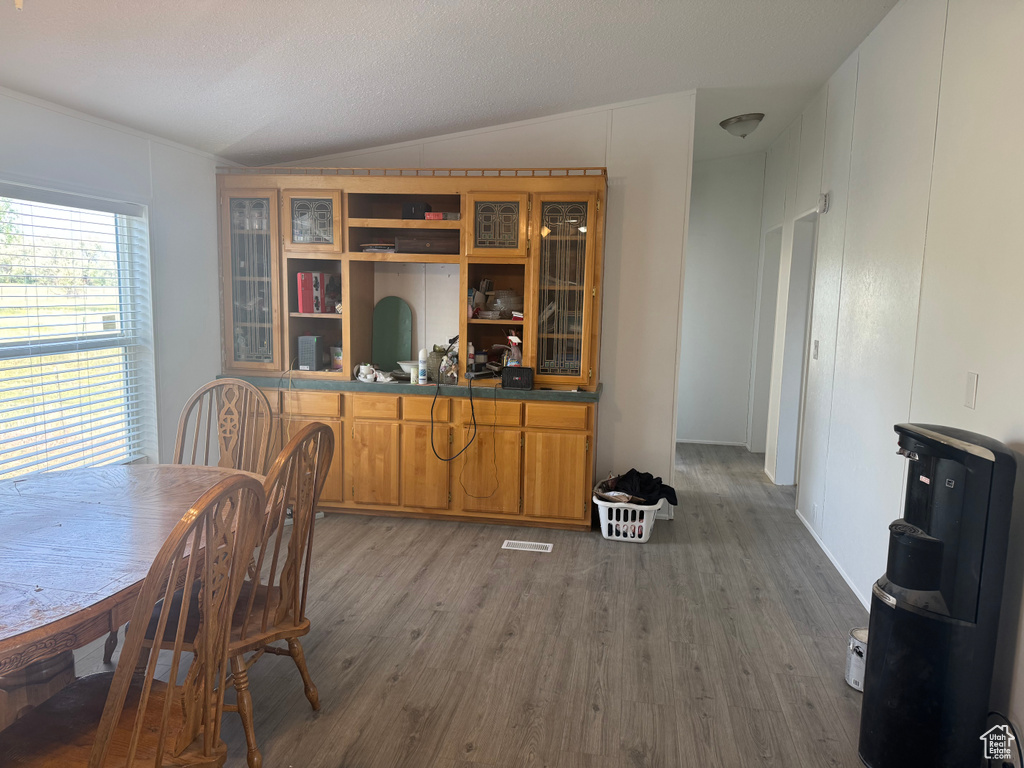 Dining room featuring vaulted ceiling and wood finished floors