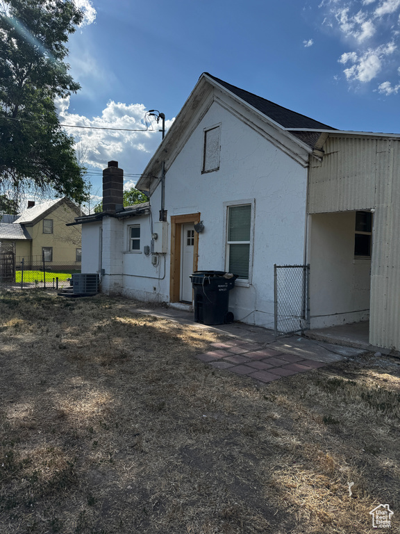 Rear view of property featuring a chimney and stucco siding