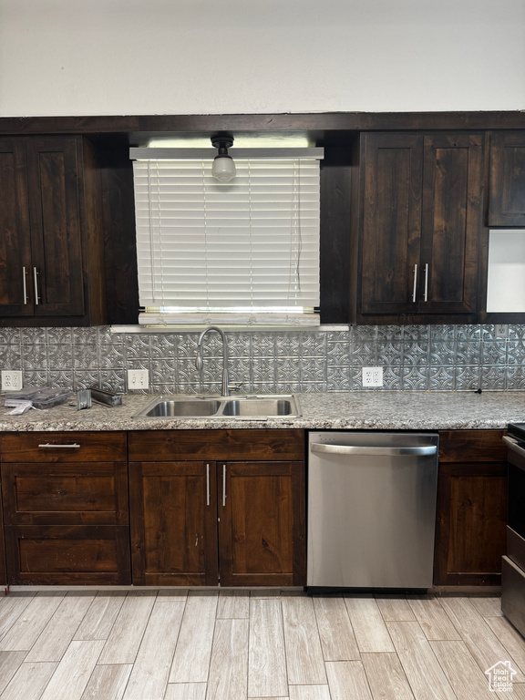 Kitchen featuring stainless steel dishwasher, tasteful backsplash, light wood-style floors, and dark brown cabinetry