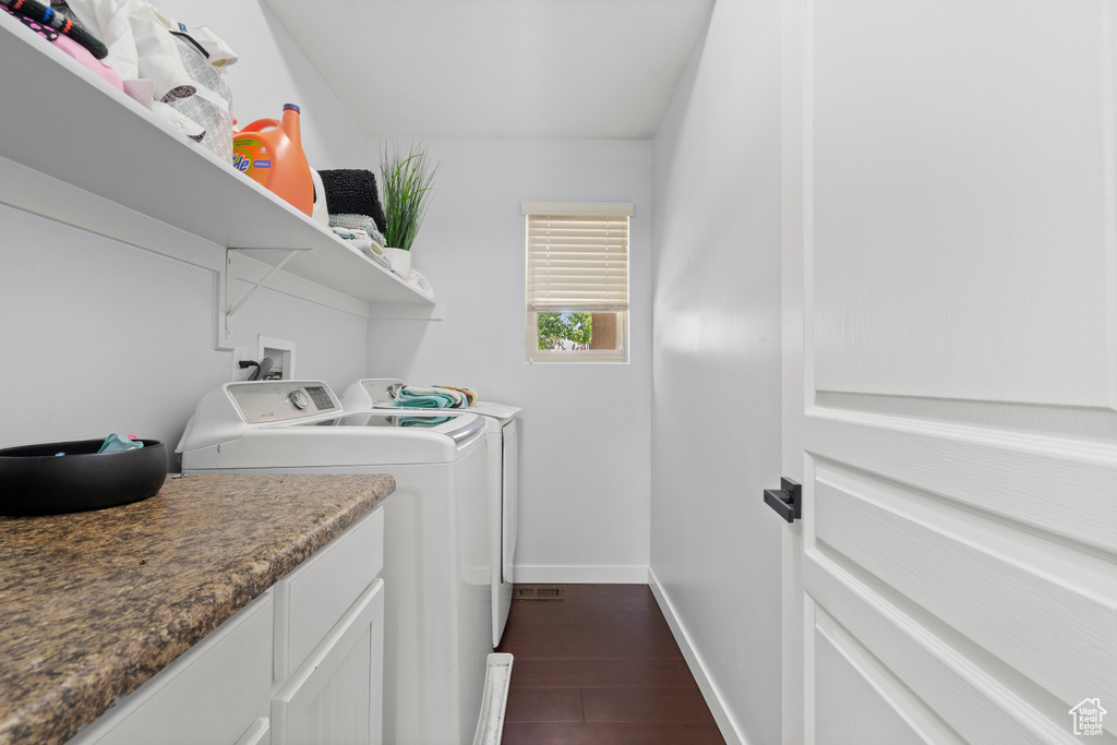 Laundry area with separate washer and dryer, baseboards, and dark wood-style flooring