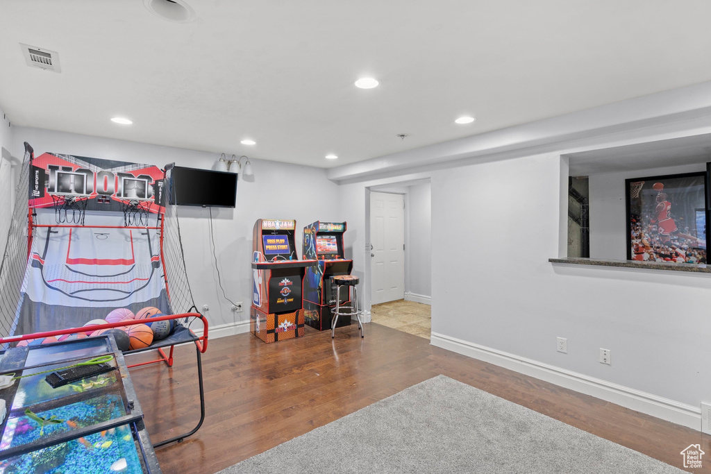Game room featuring baseboards, wood finished floors, and recessed lighting