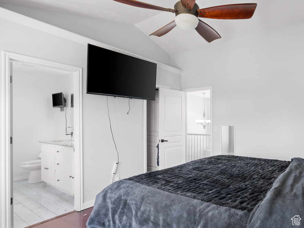 Bedroom with vaulted ceiling, wood finished floors, ceiling fan, and ensuite bathroom