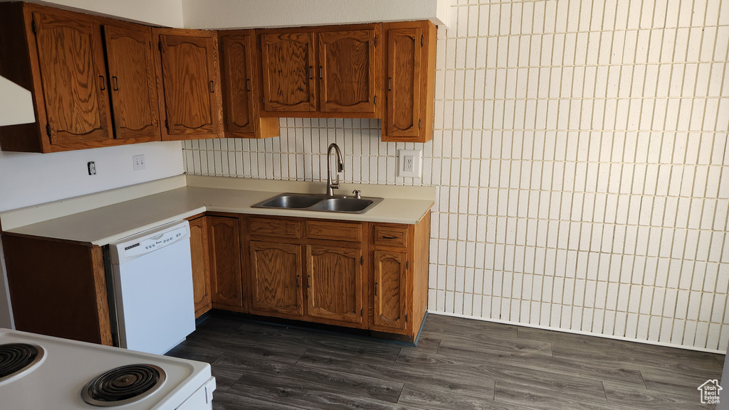 Kitchen featuring a sink, white appliances, light countertops, and brown cabinets