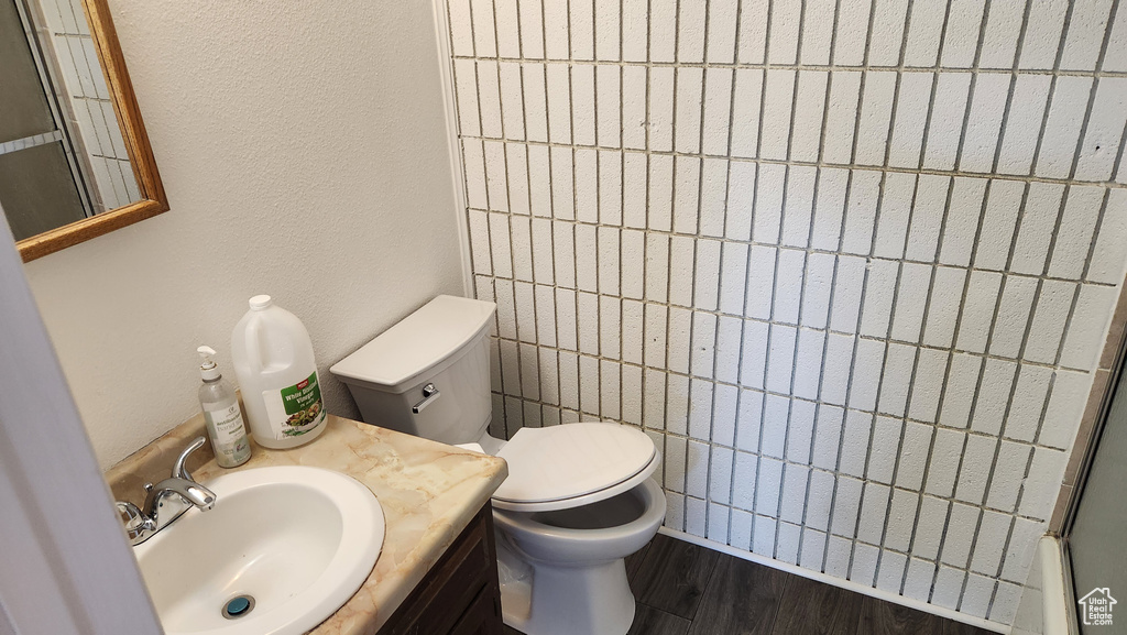 Bathroom with toilet, wood finished floors, and vanity