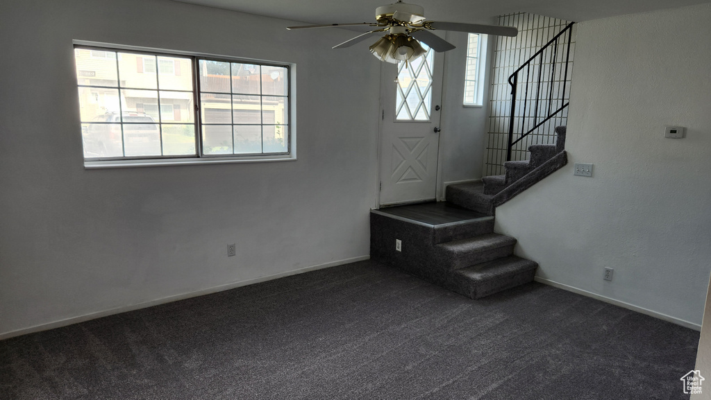 Staircase with carpet floors, ceiling fan, and baseboards