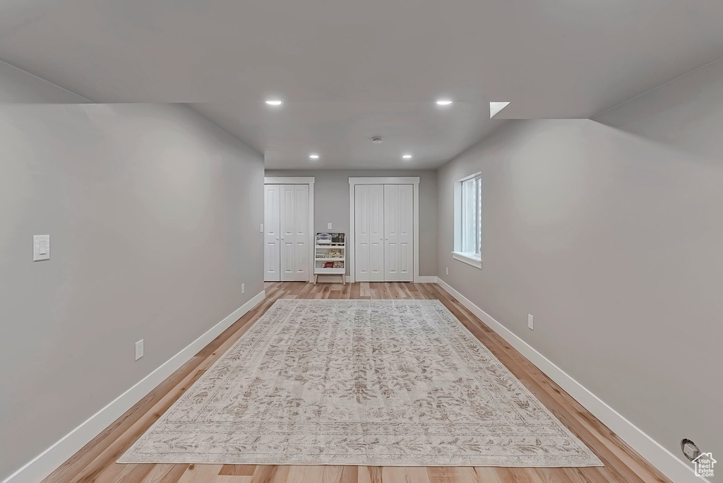 Basement featuring light wood-style flooring, baseboards, and recessed lighting