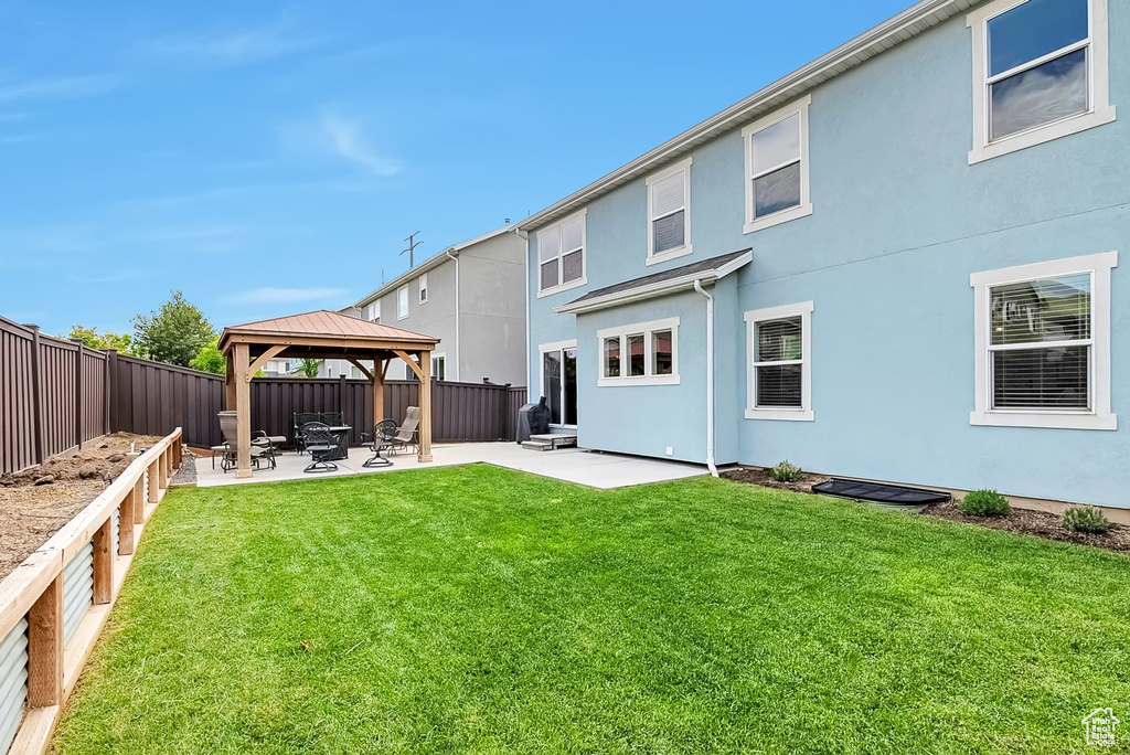 Back of property featuring a gazebo, a patio, and stucco siding