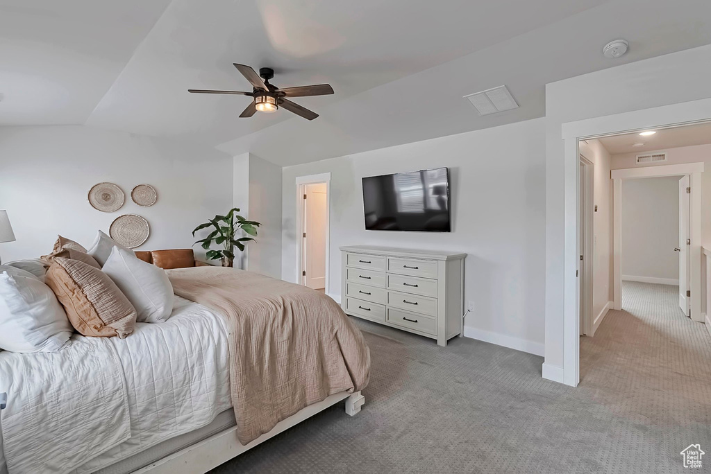 Carpeted bedroom featuring lofted ceiling, baseboards, and a ceiling fan