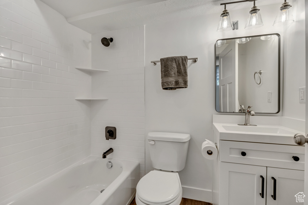 Bathroom with vanity, bathtub / shower combination, toilet, and baseboards