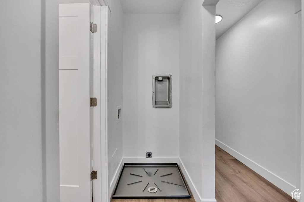 Laundry room with wood finished floors, baseboards, and hookup for an electric dryer