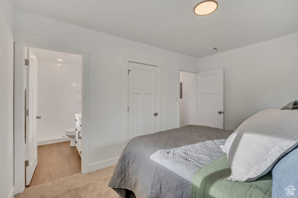 Bedroom with ensuite bathroom and baseboards