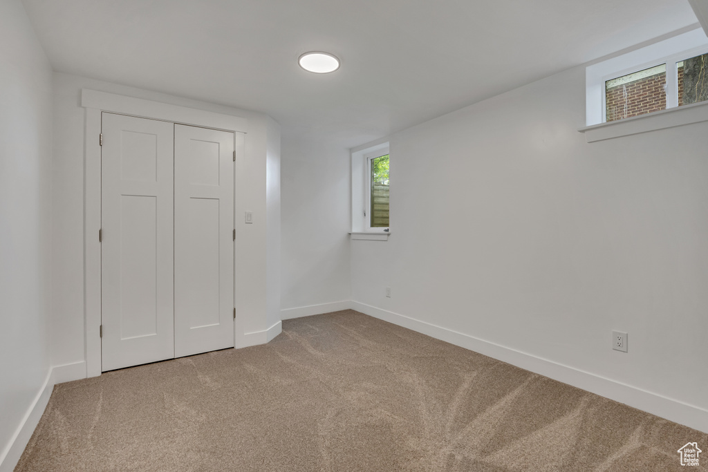 Unfurnished bedroom featuring carpet, baseboards, and a closet