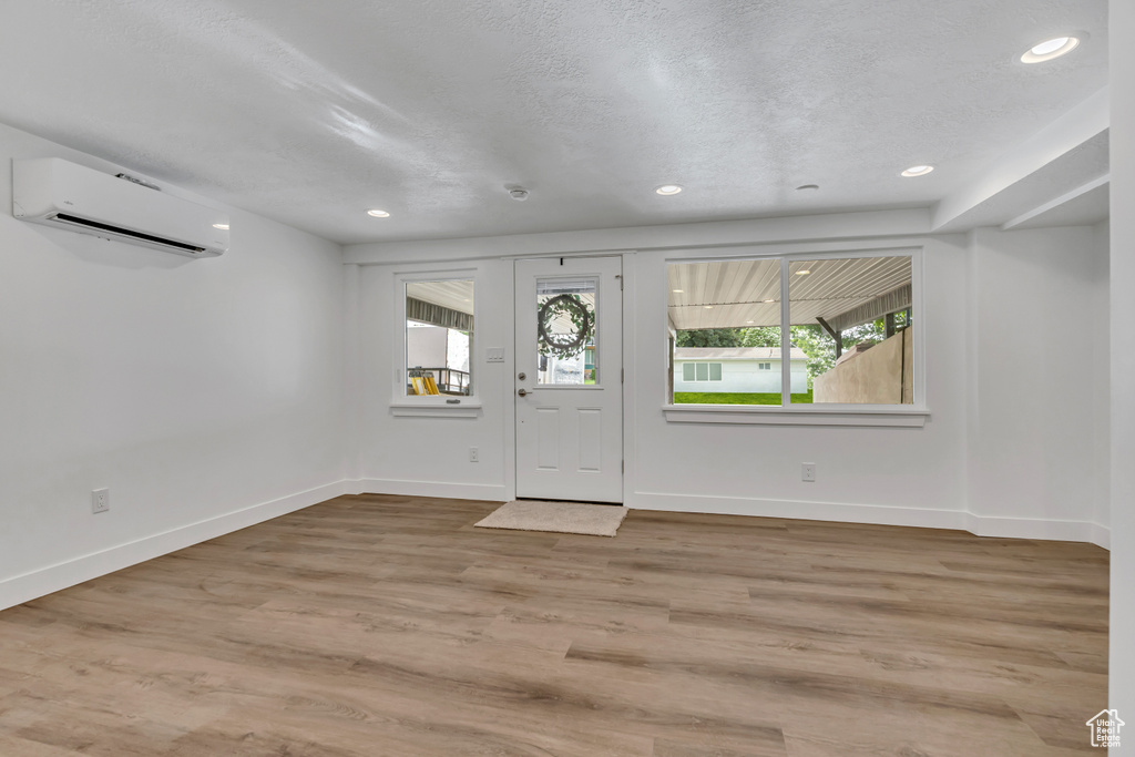 Entryway featuring a wall unit AC, recessed lighting, baseboards, and wood finished floors