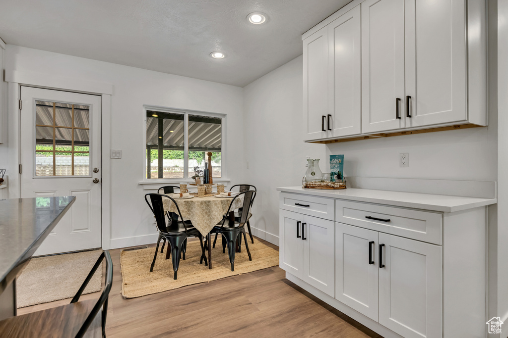 Dining room with light wood-style floors, baseboards, and recessed lighting