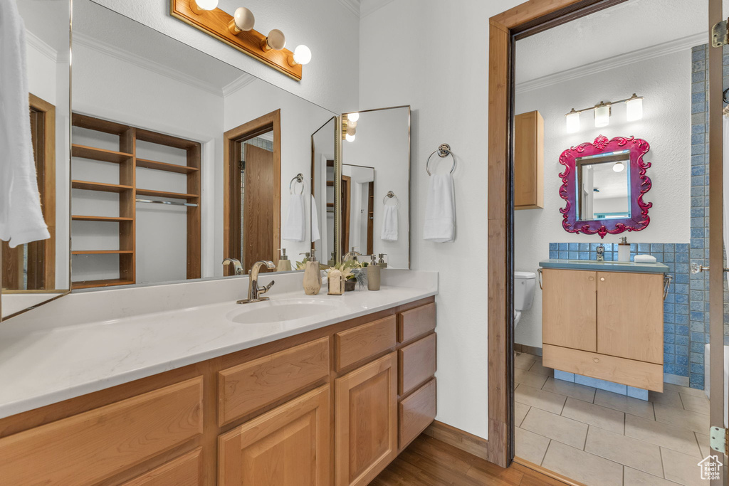 Bathroom featuring ornamental molding, vanity, toilet, tile patterned flooring, and baseboards