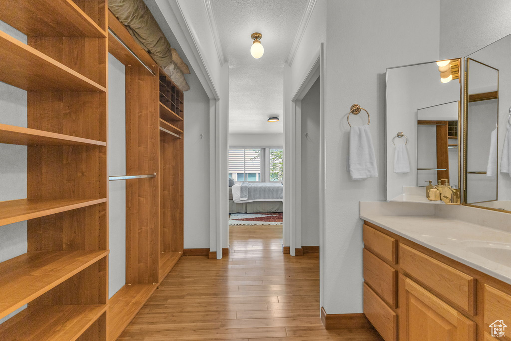 Bathroom with vanity, wood-type flooring, ensuite bathroom, and baseboards