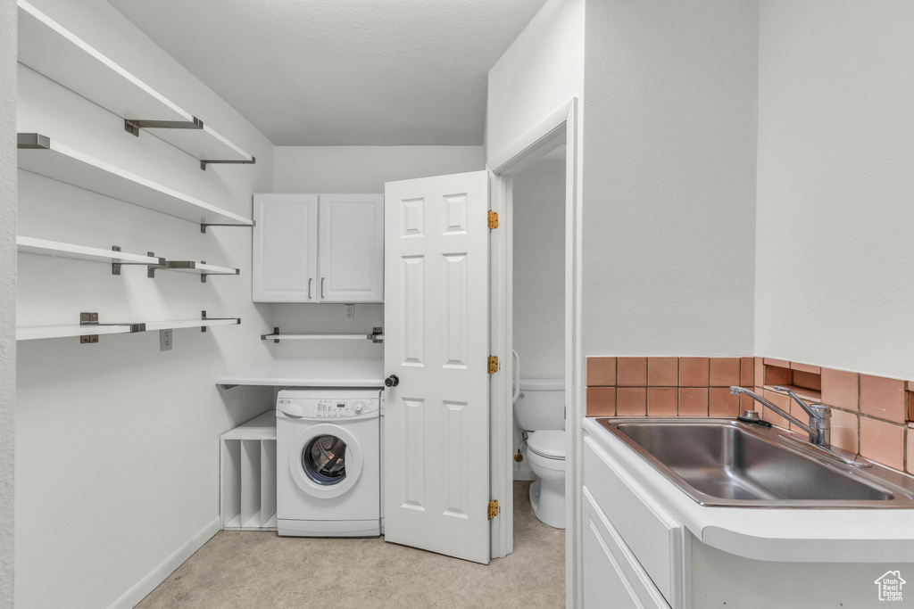 Washroom featuring washer / clothes dryer, light carpet, and baseboards