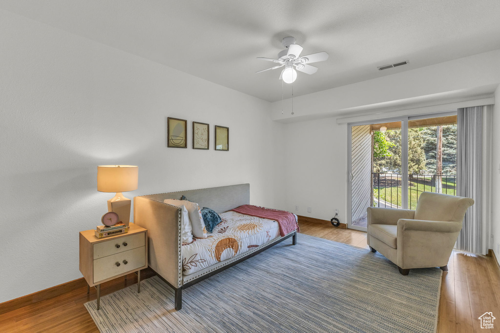 Bedroom with wood finished floors, access to outside, ceiling fan, and baseboards