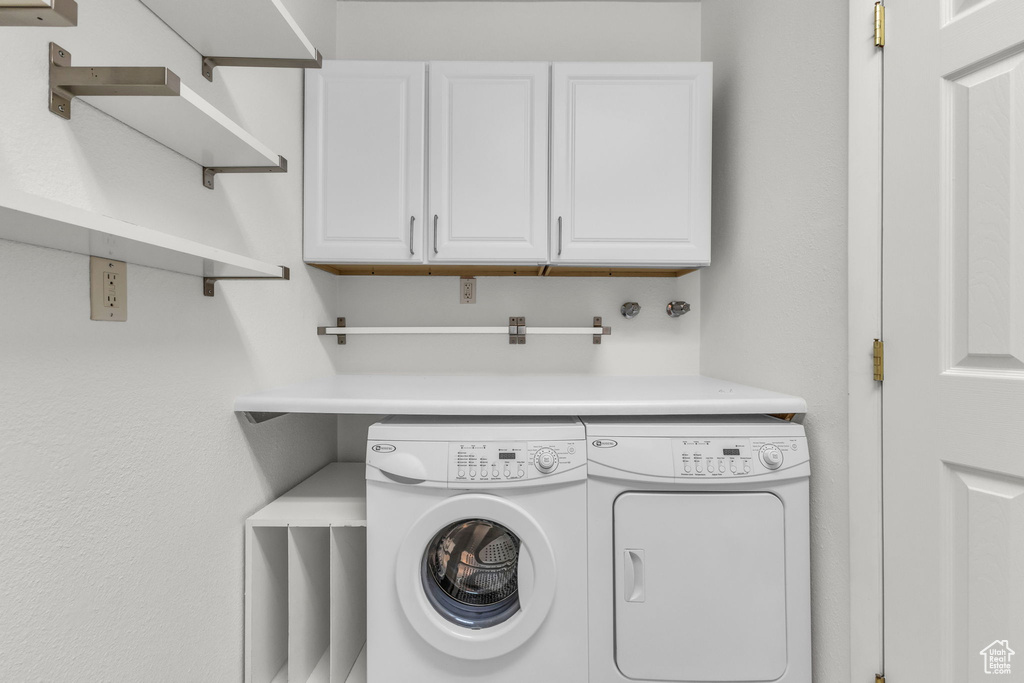 Laundry area featuring cabinet space and separate washer and dryer