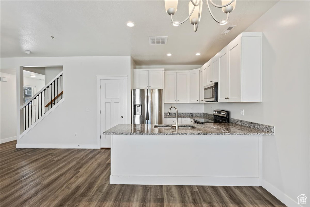 Kitchen with stainless steel appliances, a sink, baseboards, stone countertops, and recessed lighting