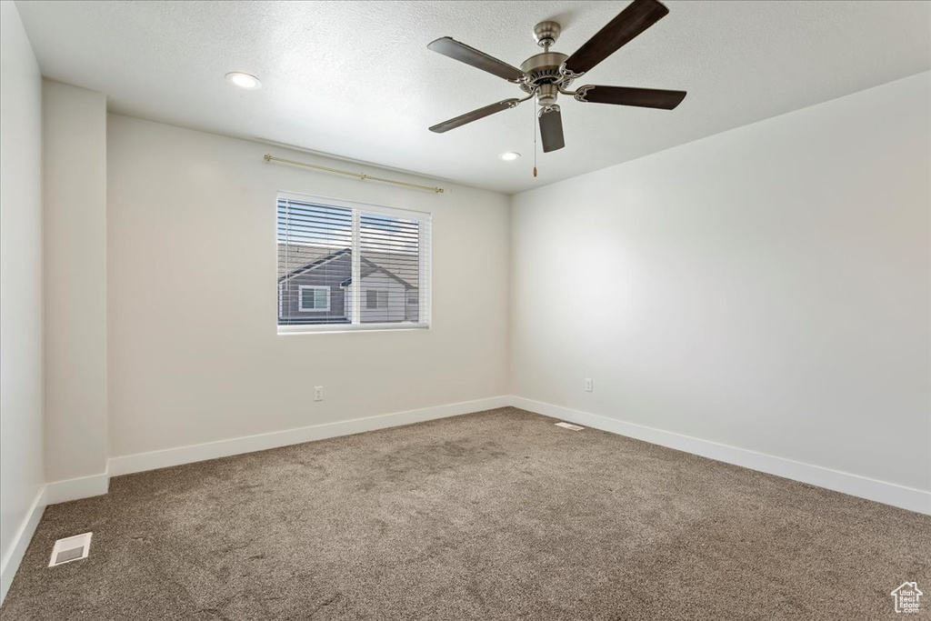 Carpeted spare room featuring baseboards, a ceiling fan, and recessed lighting