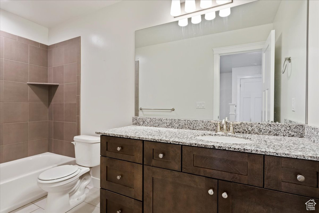 Full bath featuring toilet, vanity, tile patterned floors, and shower / washtub combination