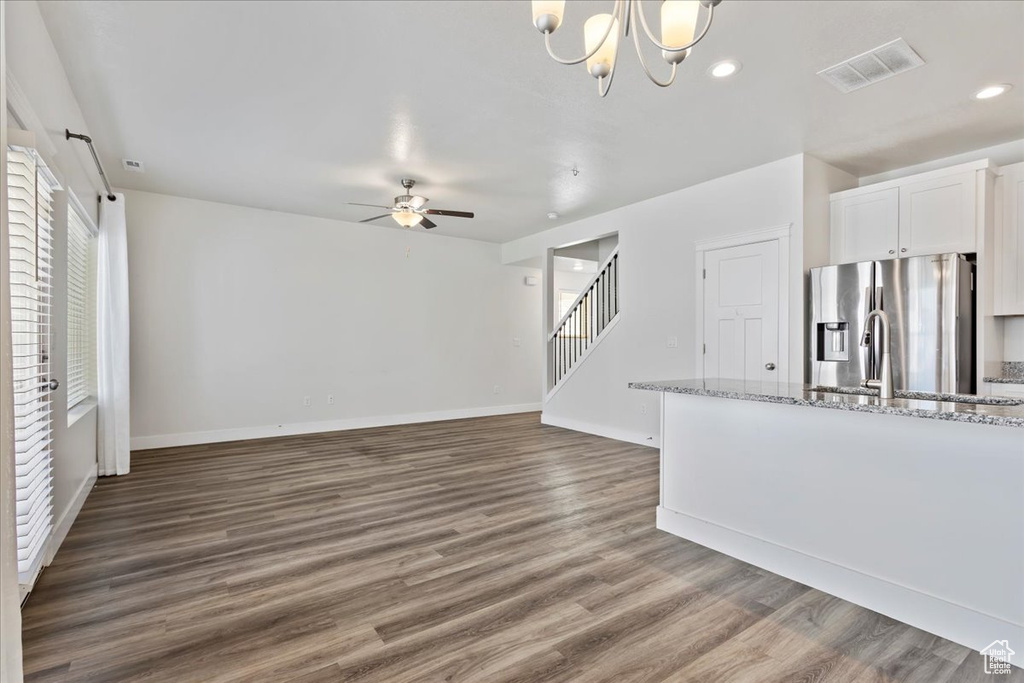 Unfurnished living room with ceiling fan, dark wood finished floors, stairway, baseboards, and recessed lighting