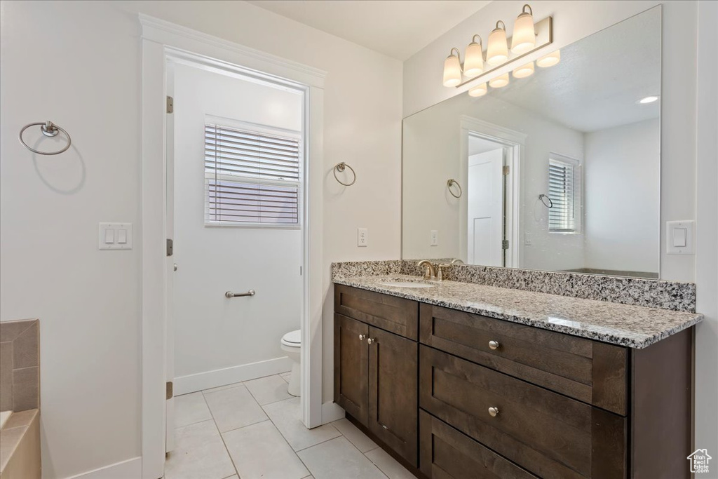 Full bathroom featuring vanity, toilet, tile patterned flooring, and baseboards