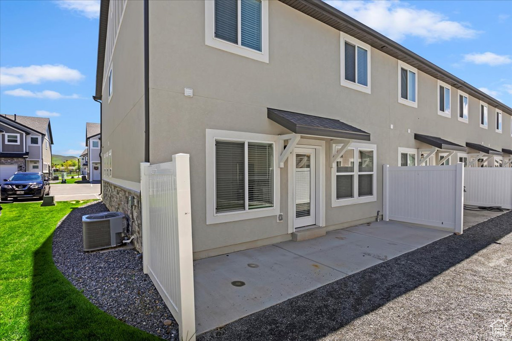 Back of house with central AC, a patio area, and stucco siding