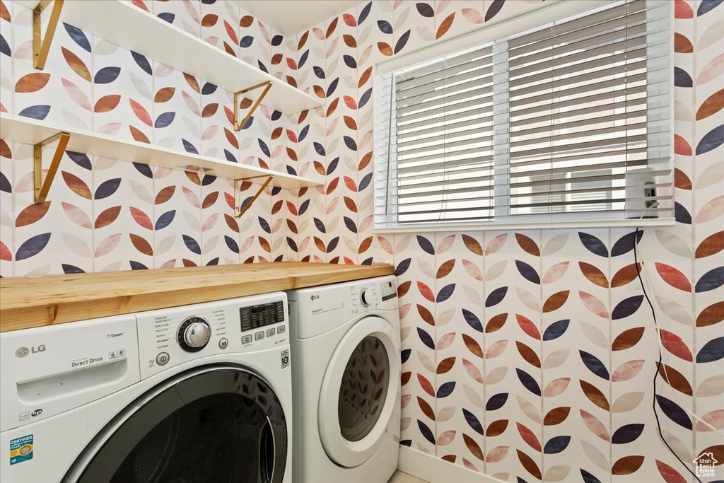 Laundry room featuring washing machine and clothes dryer and wallpapered walls