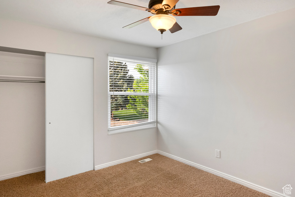 Unfurnished bedroom with carpet flooring, a closet, and baseboards