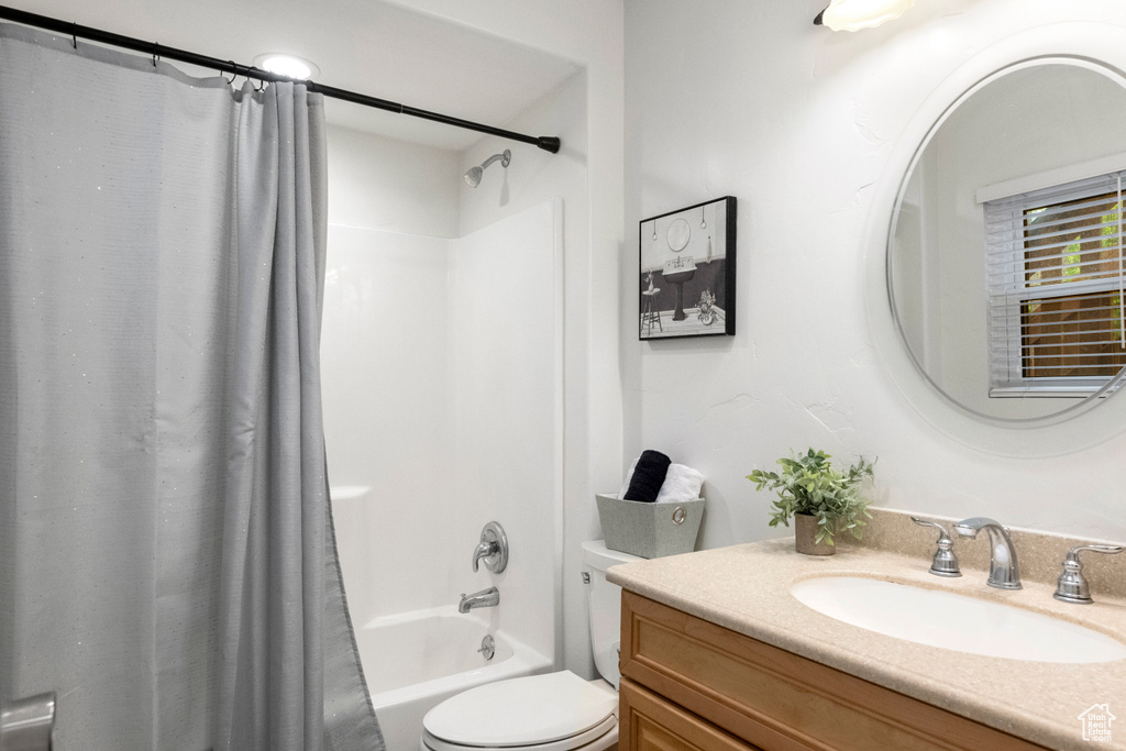 Full bathroom with toilet, shower / tub combo, and vanity