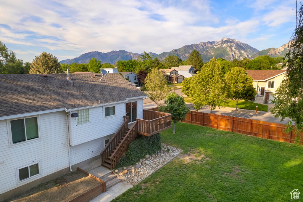 Back of house featuring a deck with mountain view, stairs, a shingled roof, and a residential view