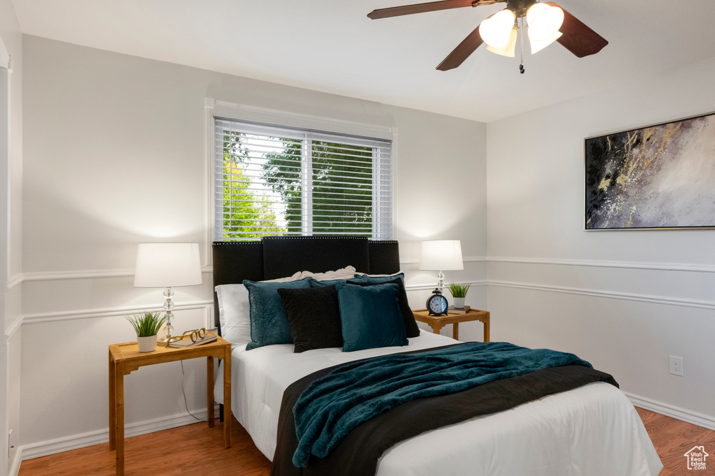 Bedroom with wood finished floors, ceiling fan, and baseboards