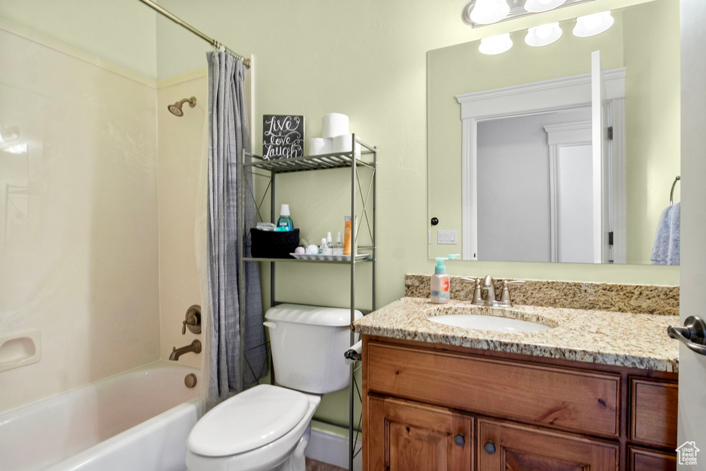 Full bathroom with shower / bath combo with shower curtain, toilet, and vanity