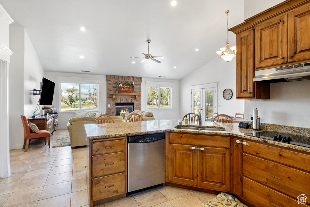 Kitchen featuring stainless steel dishwasher, under cabinet range hood, a sink, a ceiling fan, and a brick fireplace