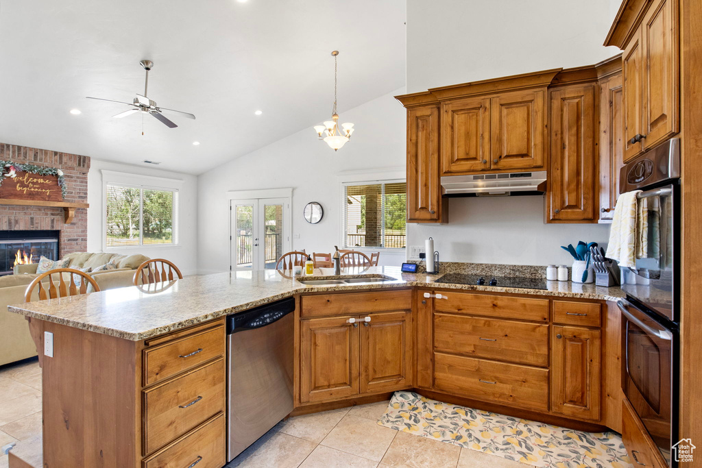 Kitchen with stainless steel dishwasher, under cabinet range hood, a sink, double wall oven, and a ceiling fan