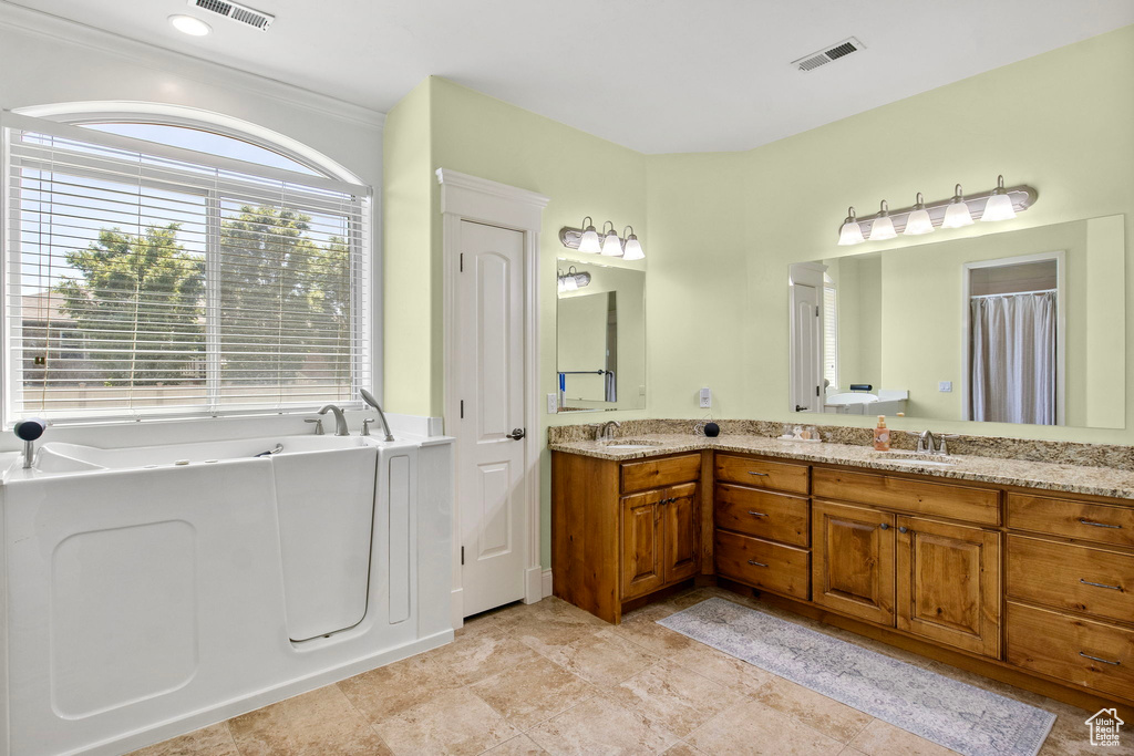 Bathroom featuring double vanity and a garden tub