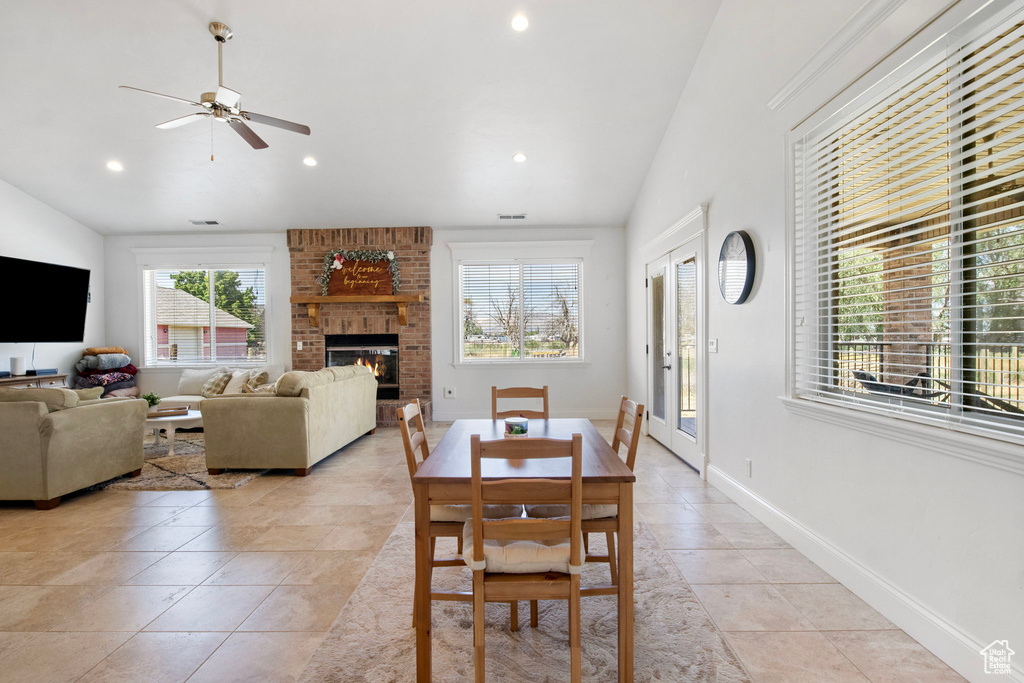 Dining area with plenty of natural light, a ceiling fan, a fireplace, recessed lighting, and lofted ceiling