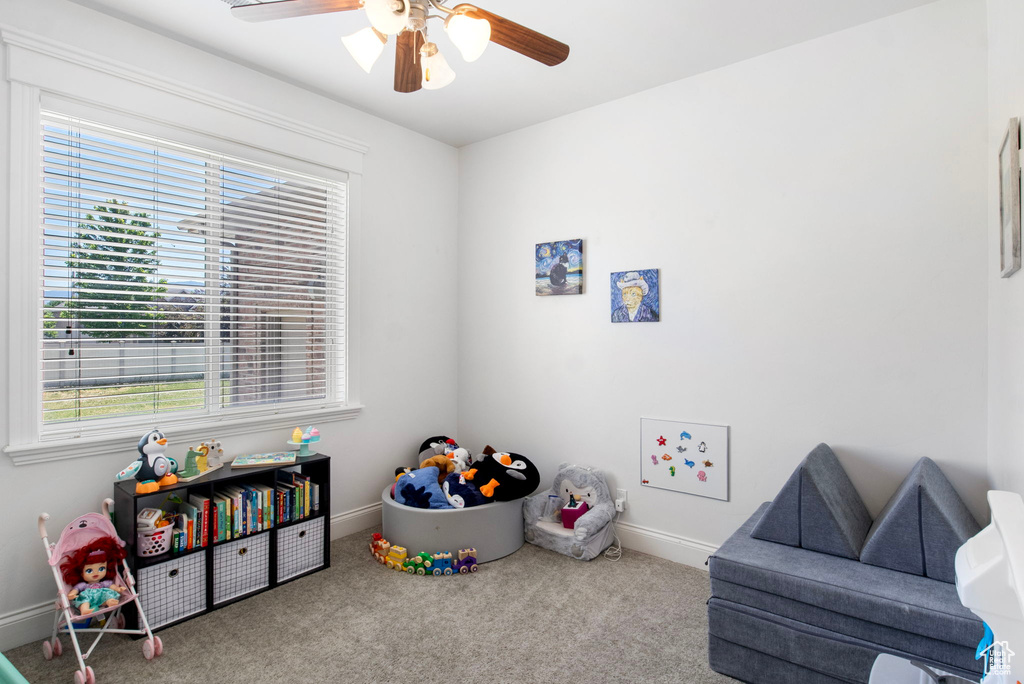 Game room with carpet, ceiling fan, plenty of natural light, and baseboards