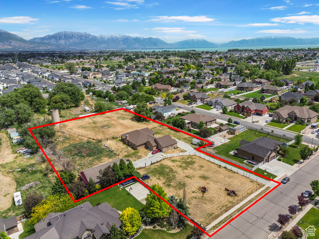 Aerial view of residential area featuring a mountain backdrop and property parcel outlined